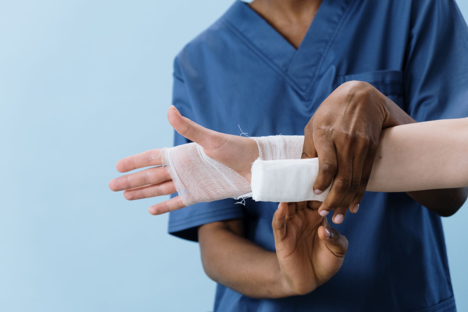 Healthcare professional wrapping a wound dressing